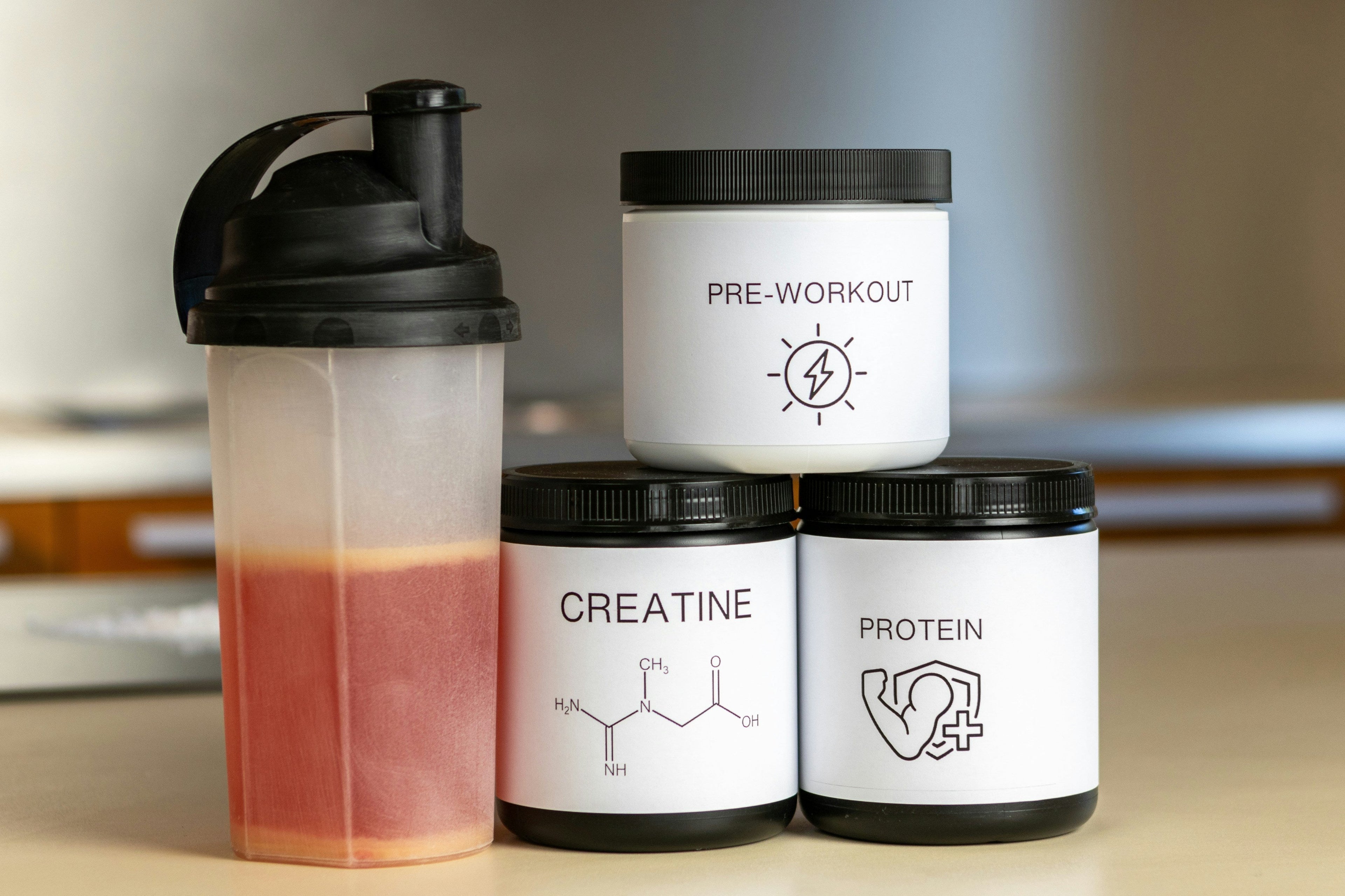 Photo credits: Saks, A. (2023). Pre-workout drink bottle and three jars with pre-work, creatine and protein [Photograph]. Unsplash. https://unsplash.com/photos/three-containers-of-protein-powder-next-to-a-blender-7lQ1m08Z7eE